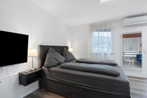 a bedroom with a bed and a flat screen tv at Motel Ambiente 1 - Luxus Studio in Bad Säckingen
