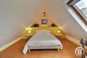 a bedroom with a bed and two tables with lamps at Le havre de kerariou in Trébeurden