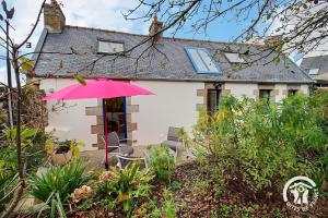 a pink umbrella in front of a house at Le havre de kerariou in Trébeurden