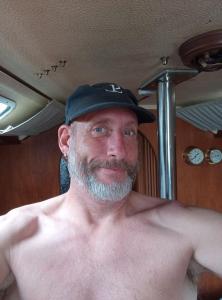 ein Mann ohne Hemd, der einen schwarzen Hut trägt in der Unterkunft Bakarvågen 2 