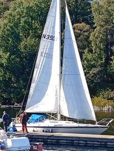 ein Segelboot auf dem Wasser mit Menschen darauf in der Unterkunft Bakarvågen 2 
