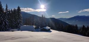 a snow covered mountain with the sun in the sky at Reh's Wiesen Hütte in Luson