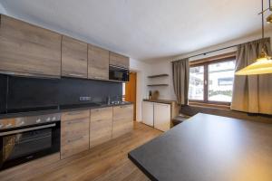 a kitchen with wooden cabinets and a table in it at Oma FRIEDA in Hollersbach im Pinzgau