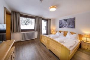 a bedroom with a large wooden bed with white pillows at Oma FRIEDA in Hollersbach im Pinzgau
