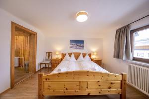 a bedroom with a wooden bed and a window at Oma FRIEDA in Hollersbach im Pinzgau