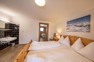 a bedroom with a bed and a sink and a mirror at Oma FRIEDA in Hollersbach im Pinzgau +3 photos