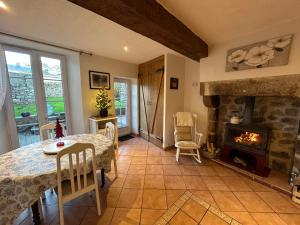 un soggiorno con tavolo e camino di Le Cordonnier d'Autrefois - 15 minutes du Puy du Fou a Mortagne-sur-Sèvre