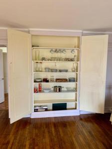Una despensa abierta con puertas blancas en una habitación. en Proche gare et centre-ville, en Chaumont