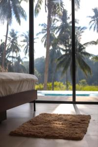 Schlafzimmer mit einem Bett und einem großen Fenster mit Palmen in der Unterkunft Modern Pool Villa Escape in Koh Phangan in Ko Phangan