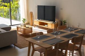 ein Wohnzimmer mit einem Tisch und einem Flachbildfernseher in der Unterkunft Modern Pool Villa Escape in Koh Phangan in Ko Phangan