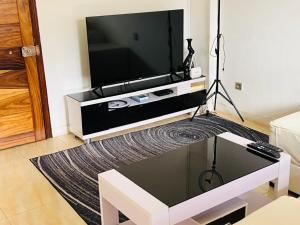 Apartamento Rua Rainha Ginga في لواندا: غرفة معيشة مع تلفزيون بشاشة مسطحة على الحائط