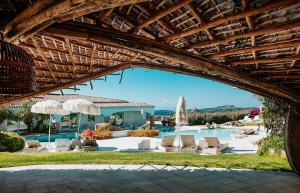 a view of the pool at a resort with chairs and umbrellas at Hotiday Baja Sardinia Saline in Cala Bitta +8 photos