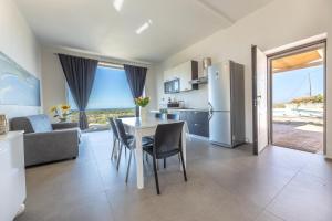 a kitchen and living room with a table and chairs at Villa Alba Chiara in Serranova