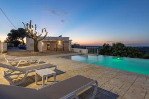 a villa with a swimming pool at dusk at Villa Alba Chiara in Serranova