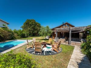a patio with a table and chairs next to a pool at Maison familiale style loft à Biscarrosse - 10 personnes, piscin - FR-1-319-563 in Biscarrosse