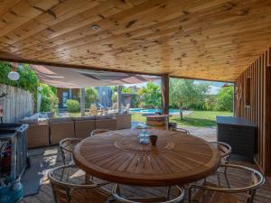a wooden table and chairs on a patio at Maison familiale style loft à Biscarrosse - 10 personnes, piscin - FR-1-319-563 in Biscarrosse