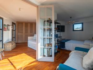 a living room with a bed and a book shelf at Maison familiale style loft à Biscarrosse - 10 personnes, piscin - FR-1-319-563 in Biscarrosse