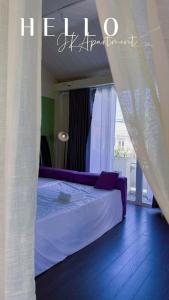 Cozy 2BR Retreat with Outdoor Living & Garden في دا نانغ: غرفة نوم مع سرير مع ملاءات أرجوانية ونافذة