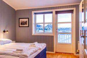 a bedroom with a bed and a window at Rorbuene Svolvær Havn in Svolvær