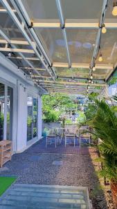 Cozy 2BR Retreat with Outdoor Living & Garden في دا نانغ: فناء على كراسي وطاولات على شرفة