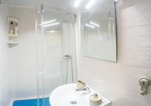 a white bathroom with a sink and a shower at Casa Chica in Málaga +27 photos