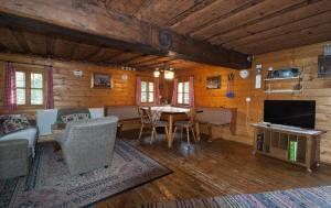 a living room with a table and chairs and a television at Reinhoferhütte in Kasperle