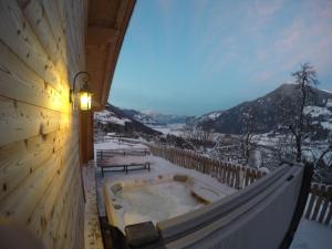 a jacuzzi tub on a balcony with a mountain at Premium Chalet Zirbe in Emberg
