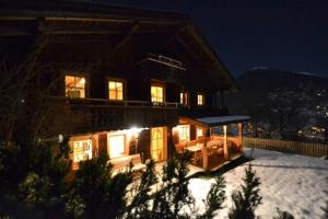 a house in the snow at night at Premium Chalet Zirbe in Emberg