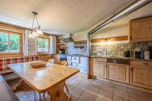 a large kitchen with a wooden table in a room at Premium Chalet Zirbe in Emberg