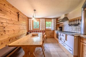a kitchen with a wooden table in a room at Premium Chalet Zirbe in Emberg +22 photos
