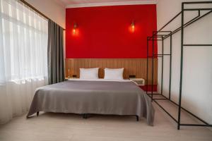 a bedroom with a large bed with a red wall at Ola Hotel in Antalya