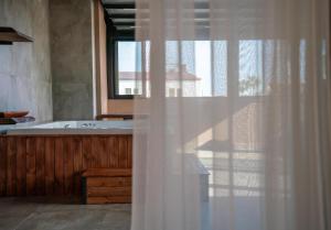 a bathroom with a tub and a white shower curtain at Ola Hotel in Antalya