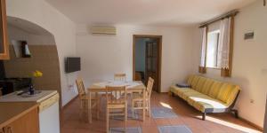 a kitchen and a living room with a table and a couch at Flora in Sveti Nicola