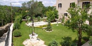 a garden with a statue in the middle of a yard at Flora in Sveti Nicola