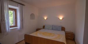 a small bedroom with a bed and a window at Flora in Sveti Nicola