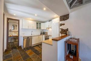 Una cocina con gabinetes blancos y encimera. en Casa Los Morros, en Tazacorte