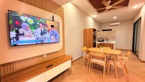 a dining room with a table and a television on a wall at Me'Lawwa Studio -Private Pool- in Kampung Padang Masirat