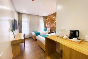 Una habitación de hotel con dos camas y un escritorio. en Aberry Shore Resort La Union Hotel, 