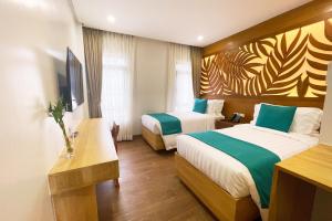 Una habitación de hotel con dos camas y un televisor. en Aberry Shore Resort La Union Hotel,  78 fotos más