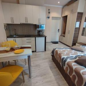 a room with a bed and a table and a kitchen at Бежевые апартаменты in Batumi