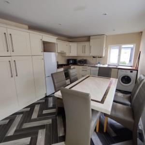 Fantastic Location! في دبلن: مطبخ مع خزائن بيضاء وطاولة وكراسي