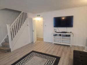 a living room with a flat screen tv on the wall at Oakfield Gardens NY in Edmonton