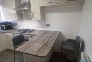 a kitchen with a wooden counter top and two chairs at Oakfield Gardens NY in Edmonton