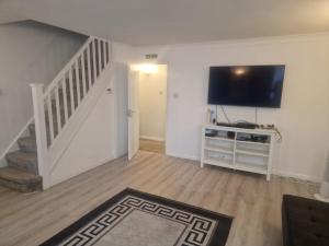 a living room with a flat screen tv on a wall at Oakfield Gardens NY in Edmonton +2 photos