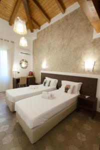 a bedroom with two beds and a desk in a room at Alterego B&B in Milazzo