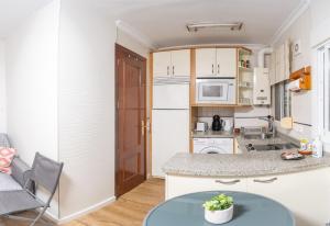 a small kitchen with a counter and a table at Casa Chica in Málaga