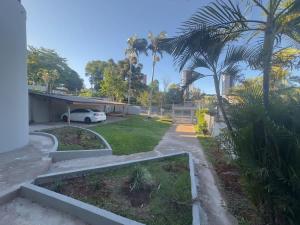 Studio no Centro de Foz Até 6 Hóspedes في فوز دو إيغواسو: منظر لمدخل منزل به أشجار نخيل +7 صور