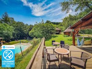 a deck with tables and chairs and a playground at Camping 2 étoiles - Piscine - ccb0hef in Fenouillet