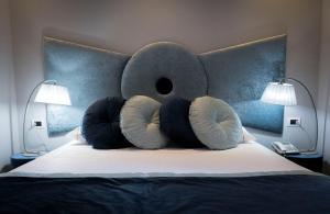 a bed with a headboard with pillows and two lamps at Opera House Guest, Roma centro storico in Rome