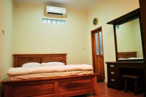 a bedroom with a bed and a dresser and a mirror at Pondok Sukamanah Tasik in Tasikmalaya